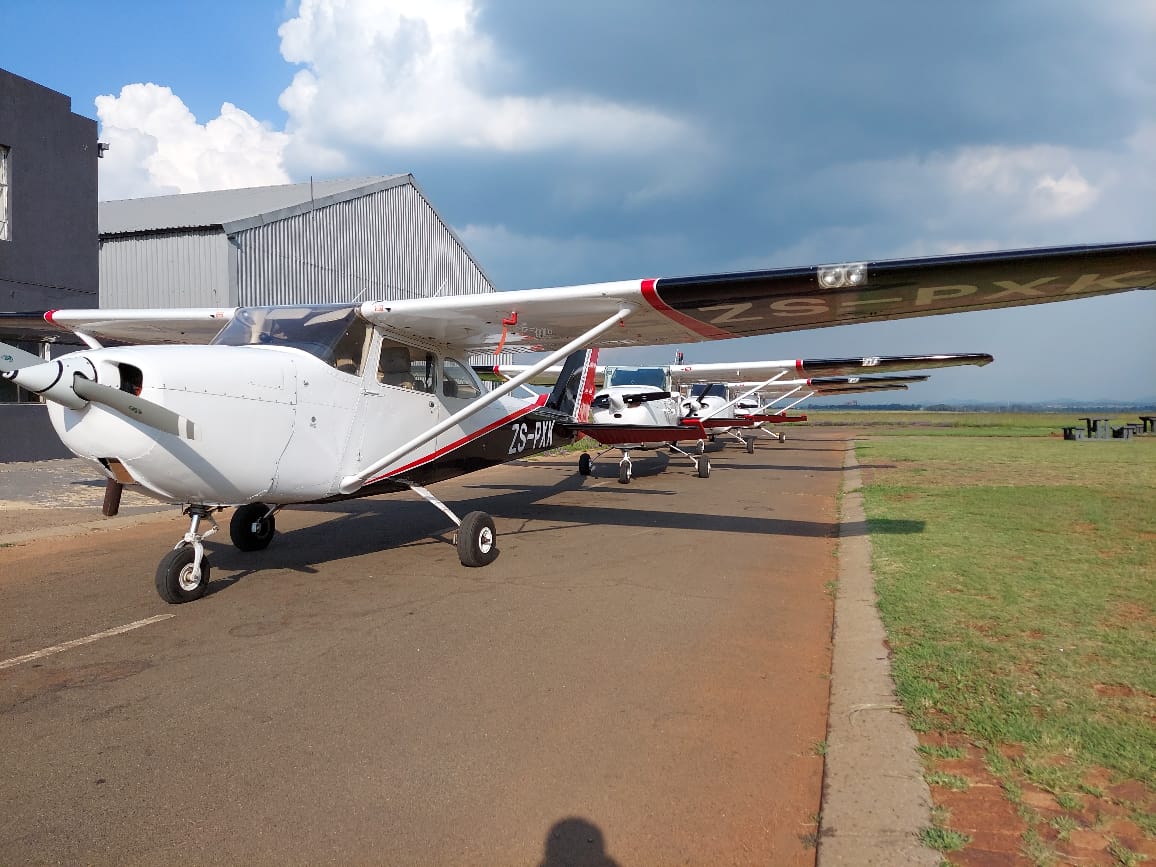 Two Cessna aircraft parked inside the Unitas Flying Academy hangar