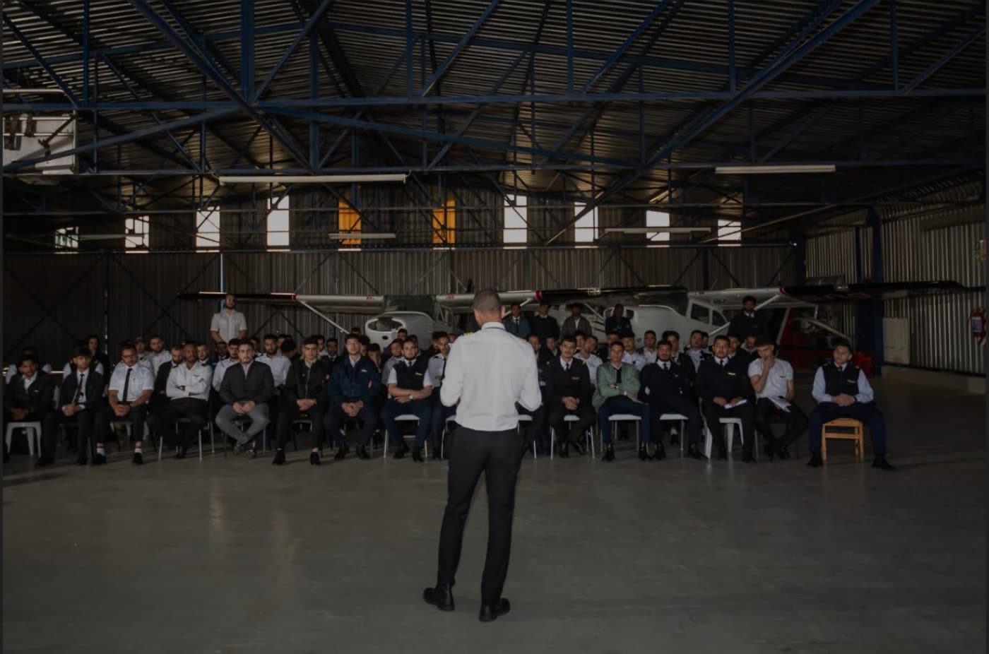 Unitas Flying Academy cadets gathered in the hangar for a briefing